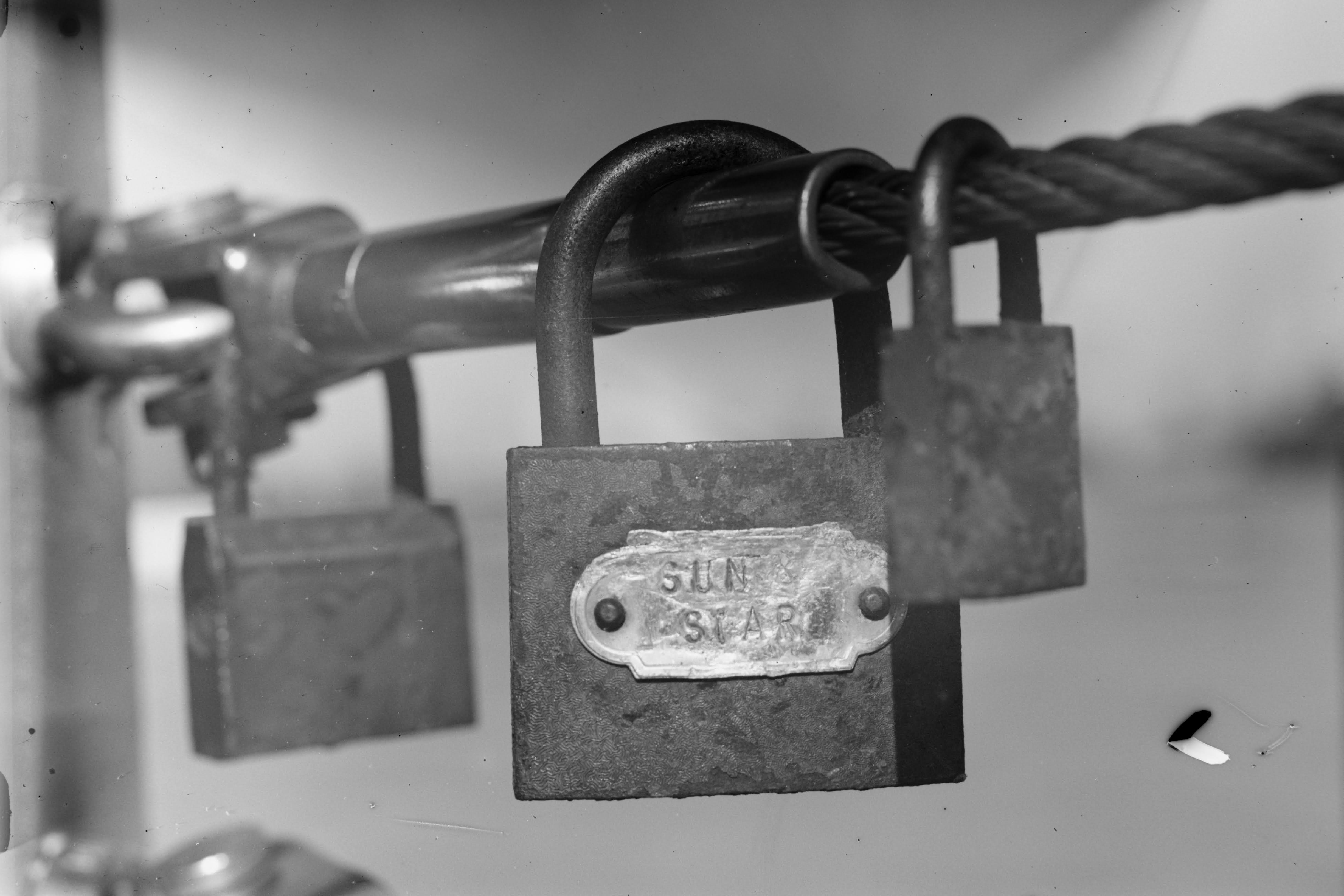 Some padlocks on a railing, showing the close focus capability, this also features a light leak from a bent dark slide, and a big chunk of damaged emulsion caused by clumsy handling
