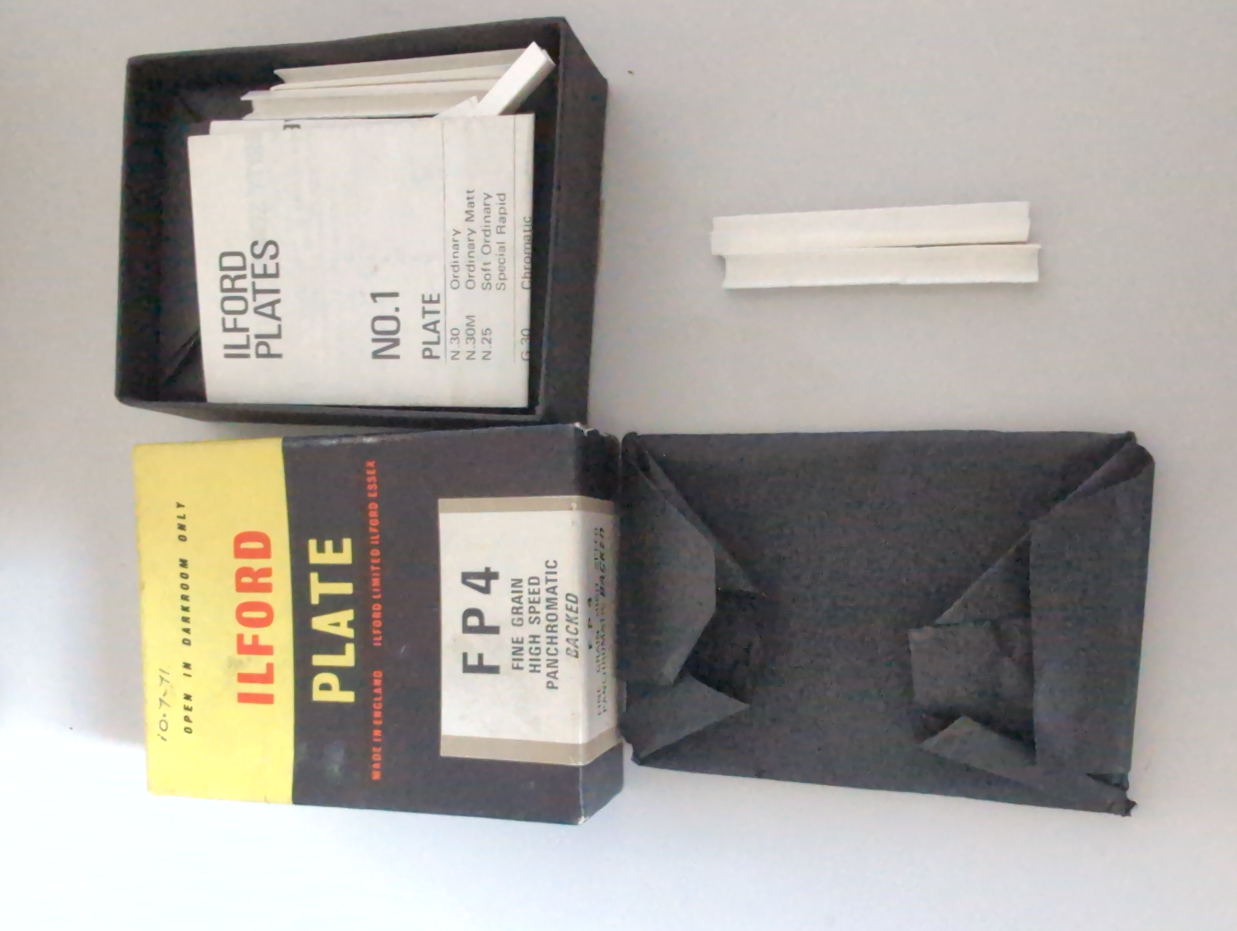 Contents of the box. The plates are packed in fours, two pairs of plates facing emulsion side in with a white cardboard separator over the edges. wrapped in a thick light tight paper.